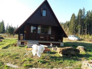 een huis met een tafel en stoelen ervoor bij Chata Jedľoviny Martin in Martin