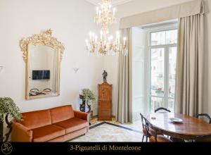 uma sala de estar com um sofá, uma mesa e um espelho em Dimora Donna Elena by Ranieri em Nápoles