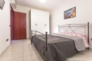 ガリポリにあるBilocale Calipsoのベッドルーム1室(ベッド1台付)、木製のドア