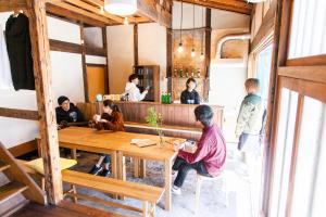 a group of people sitting at a table in a restaurant at Fukuoka Guesthouse SHIP in Fukuoka