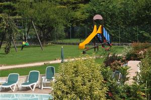 einen Spielplatz mit Stühlen und einer Rutsche in einem Park in der Unterkunft Vico Sweet mountain view in Crone