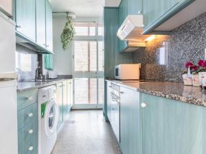 - une cuisine avec des placards bleus et un lave-linge/sèche-linge dans l'établissement Apartment Reus Mediterrani-1 by Interhome, à Vilafortuny