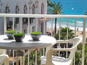 a table on a balcony with a view of the beach at Apartment Giner by Interhome in Benidorm