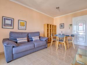 a living room with a blue couch and a table at Apartment Bahia Blanca-1 by Interhome in Denia