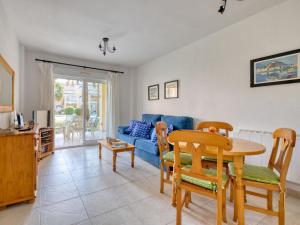 ein Wohnzimmer mit einem Tisch und einem blauen Sofa in der Unterkunft Apartment Royal Playa by Interhome in Denia