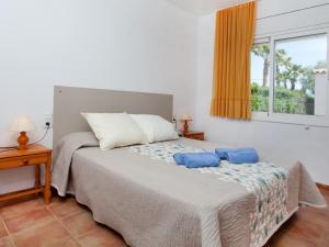 1 dormitorio con 1 cama con 2 toallas azules en Villa Villa Cala Vidre A by Interhome, en Les tres Cales