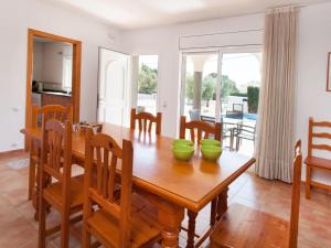 een eetkamer met een houten tafel met twee groene kommen erop bij Villa Villa Cala Vidre A by Interhome in Les tres Cales