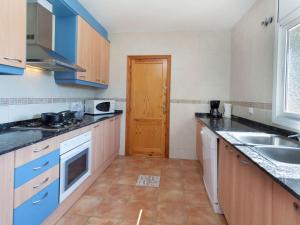 a kitchen with blue cabinets and a sink at Villa Villa Cala Vidre A by Interhome in Les tres Cales