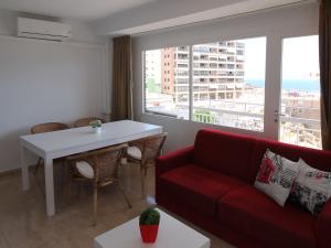 ein Wohnzimmer mit einem Sofa, einem Tisch und einem Fenster in der Unterkunft Apartment Maria by Interhome in Cala de Finestrat