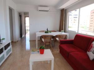 ein Wohnzimmer mit einem roten Sofa und einem Tisch in der Unterkunft Apartment Maria by Interhome in Cala de Finestrat