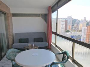 ベニドルムにあるApartment Waldorff by Interhomeのテーブルとソファ、窓が備わる客室です。