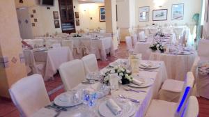 a room filled with tables and chairs with white linens at Hotel Di Nardo in Petacciato