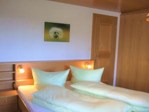 a bedroom with a bed with two pillows at Haus Adlerhorst in Sulzberg