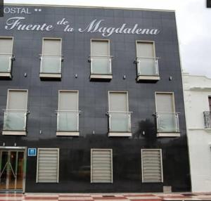 un edificio negro con ventanas y un cartel en él en Fuente de la Magdalena en Santa Amalia