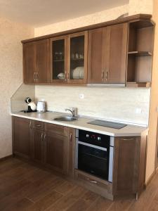 a kitchen with a sink and a stove at Apartment FREEDOM in Shkorpilovtsi