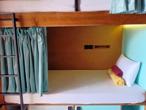 a bunk bed with a white pillow and a ladder at Stellar Capsules in Seminyak