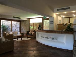 a hotel lobby with a reception counter and chairs at Green Park Hotel in Porto Cervo +27 photos