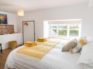 a bedroom with a large white bed with pillows on it at Cefn Nannau in Corwen