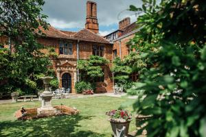 a brick house with a fountain in the yard at Seckford Hall Hotel & Spa in Woodbridge