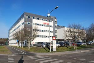 a koci building with cars parked in a parking lot at Sure Hotel by Best Western Spånga in Stockholm