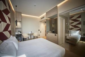 a bedroom with a white bed and a bathroom at iH Hotels Milano Ambasciatori in Milan