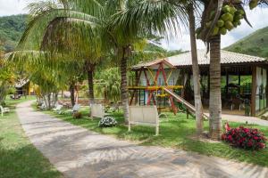 a resort with a playground and palm trees at Pousada Leonardo da Vinci in Miguel Pereira