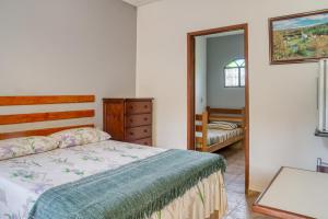 a bedroom with a bed and a dresser and a mirror at Pousada Leonardo da Vinci in Miguel Pereira