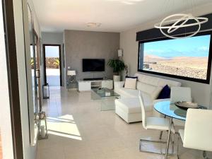 a living room with a white couch and a table at Villa Kira, Tindaya in Tindaya