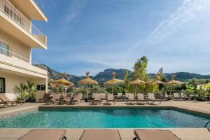 una piscina en un hotel con sillas y sombrillas en Hotel Eden Nord Soller, en Puerto de Sóller