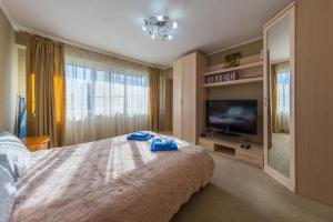 a bedroom with a large bed and a flat screen tv at Апартаменты рядом с вокзалами Сочи in Sochi
