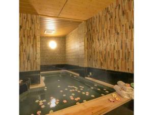 a jacuzzi tub with flowers in it in a room at Grand Park Hotel Excel Fukushima Ebisu / Vacation STAY 77713 in Fukushima