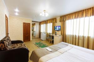 1 dormitorio con cama, silla y escritorio en Hotel Siberia, en Tobolsk