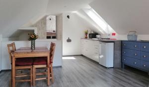 a kitchen with a table and a kitchen under a roof at Apartment Kokoro in Bogojina