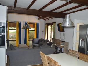 uma sala de estar com um sofá, uma mesa e cadeiras em Comfortable holiday home with private pool em Fayence