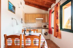 a kitchen with a table with chairs and a sink at Home2Book Stunning View La Era de Hermigua & Wifi in Hermigua