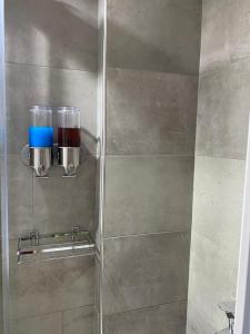 a shower stall with a glass door with two cups at Main Square Flat - LUXURY APARTMENTS XANTHI LAX in Xanthi