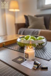 a candle and a bowl of apples on a coffee table at Grand view in Zlatibor