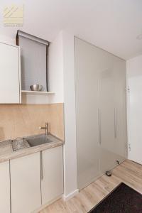 a kitchen with white cabinets and a sink at Grand view in Zlatibor