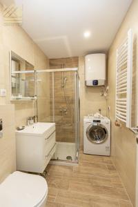 a bathroom with a shower toilet and a washing machine at Grand view in Zlatibor