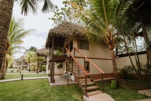 a house with a staircase leading up to it with palm trees at El Sauce Resort - Hotel Asociado Casa Andina in Sauce