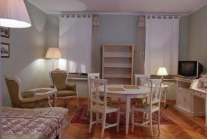 sala de estar con mesa, sillas y TV en Central Apartments Lviv, en Leópolis