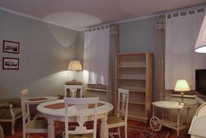 een woonkamer met een tafel en stoelen en een televisie bij Central Apartments Lviv in Lviv