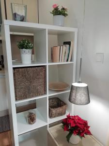 a white book shelf with plants and a lamp at Apartment in the historic center of Porto in Porto