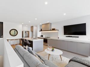 een woonkamer met een bank en een tv bij Sierra Views - Queenstown Holiday Home in Queenstown