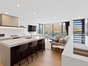 een keuken en een woonkamer met een bank en een keukeneiland bij Sierra Views - Queenstown Holiday Home in Queenstown
