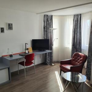 a room with a desk with a computer and chairs at Hotel Postbauer-Heng, E-Mobilität, Ladestationen für Elektroautos in Postbauer-Heng