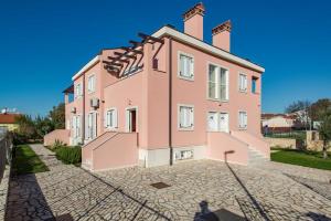 duży różowy budynek przy brukowanej ulicy w obiekcie Apartment 7 - Sea View - Daniel w Medulinie +15 zdjęć