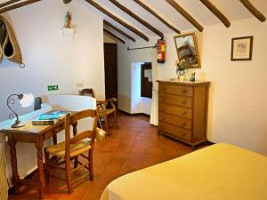 1 dormitorio con escritorio, 1 cama y 1 mesa en Acogedora casa rural en Zahara de la Sierra, en Zahara de la Sierra