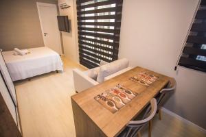 a small room with a table and a bed at Studio Central com Ar Condicionado - ALL0817 in Curitiba +34 photos
