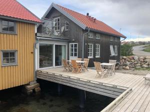 une maison dotée d'une terrasse en bois avec une table et des chaises dans l'établissement Everts Sjöbods Bed & Breakfast, à Grebbestad